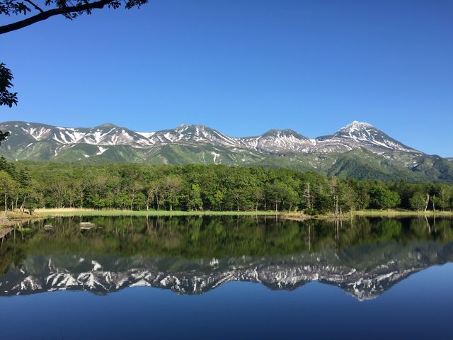 残雪の残る初夏の知床五湖。風が無い日は湖面が鏡のようになり、連山が湖面に映ります。_シンラ(SHINRA)