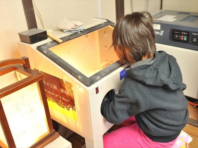 砂(研磨剤)が飛び散らないように、金属製の大きなキャビネットの中で吹きつけ作業を行います。_ガラス工房 MIKI 松阪工房