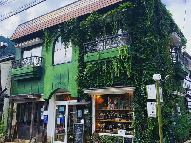 緑の建物が目を引きます。茂った植物も目印です。_cu-mu