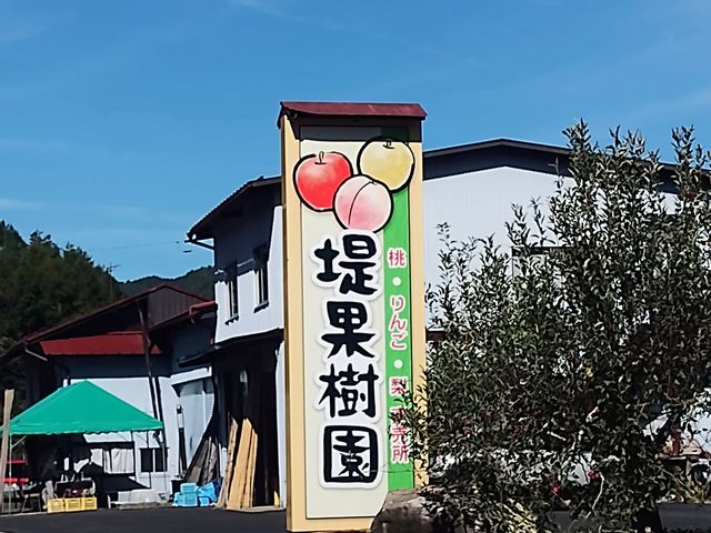 看板と建物の間が駐車場です。_堤果樹園