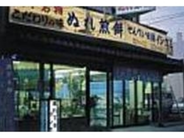 黄色い看板を掲げたガラス張りの建物が目印_ぬれ煎餅のイシガミ せんべい館