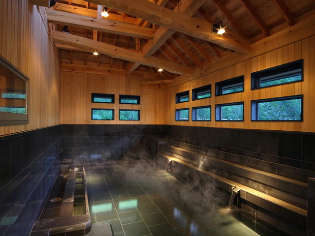 【南部曲り家の湯】「大岩の湯」(内湯)石のシックなイメージを感じるお風呂です。天井は「赤松の湯」同様に木組みの巧みを見ることができます。_ホテル紫苑