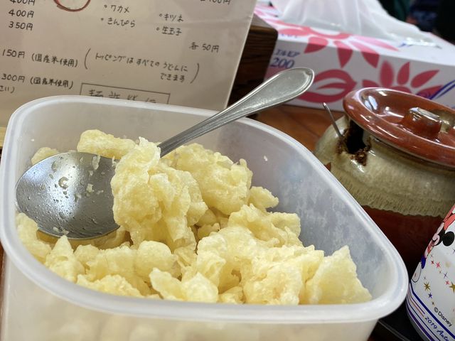 卓上に置かれた揚げ玉もボリューム満点 壺の中の薬味も辛くて香り高くて美味しい_麺許皆伝