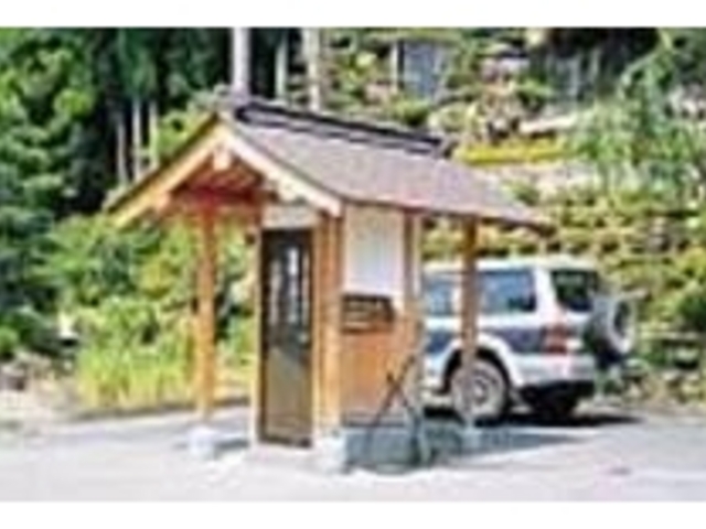 木造りの囲いの中に温泉の自動販売機がある_温泉スタンド