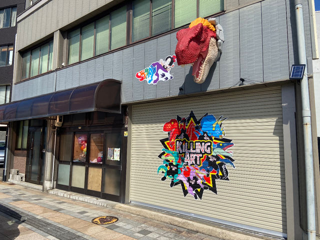 アトリエショップから赤色のティラノサウルスが顔を出しています。_キリングアート