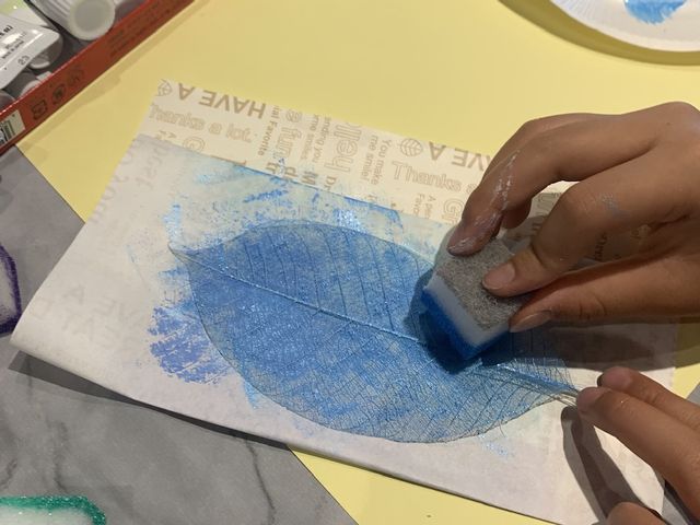 ボタニーペインティングの体験をしました。ゴムの木の葉に色を塗っている写真です。_Yaco Arts Tokyo