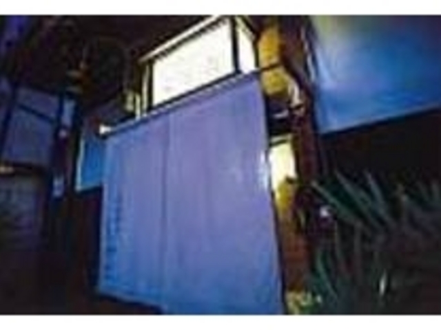 玄関の前に立つ看板と、淡い色の暖簾が目印_おばんざいの店 しかた