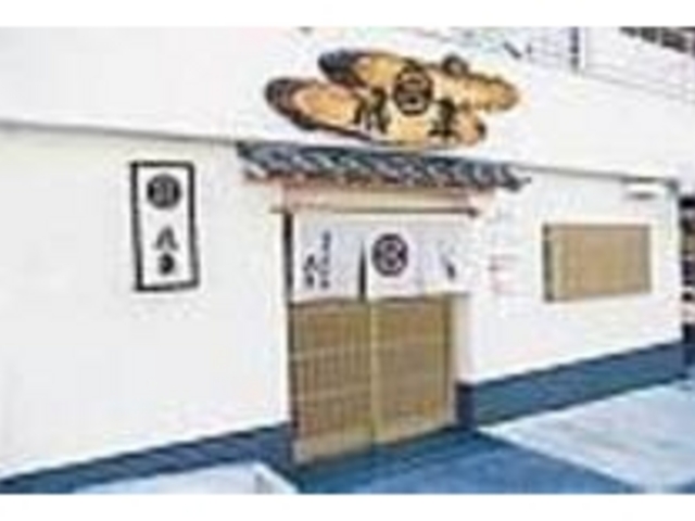 白壁と、切り株を使った看板が目印_活魚・鍋料理 風車