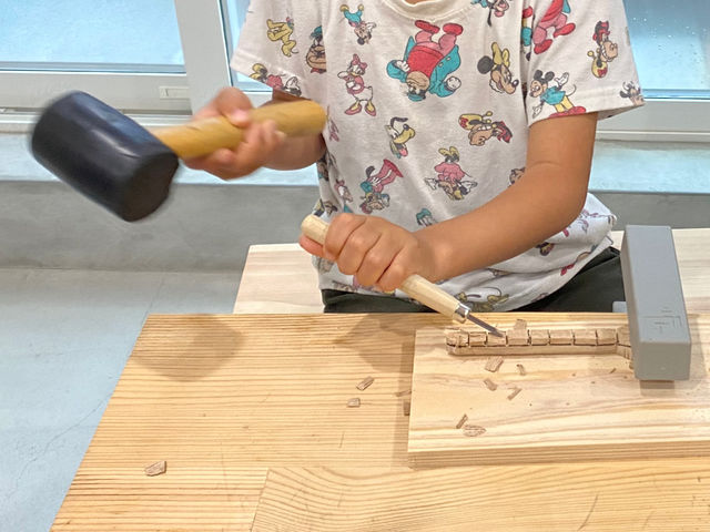 スプーン作り体験の様子です。刃物は金槌で叩きながら削っていきます。(小学生のお子様は保護者のサポートが必要です。)_しろくも工房