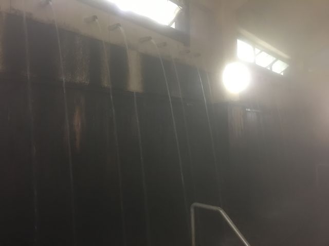 高い所にあるパイプから温泉が注がれています。_筋湯共同浴場うたせ大浴場