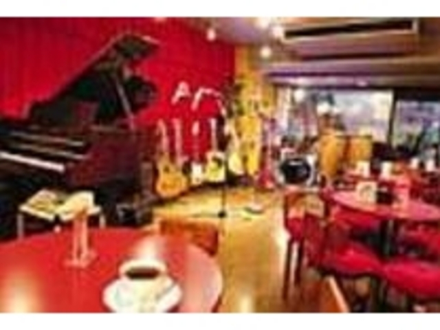 赤いテーブルや壁がポップな雰囲気の店内_Stage p・f