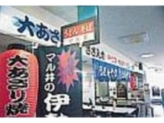 大きな旗やちょうちんが賑やかな店頭_マル井