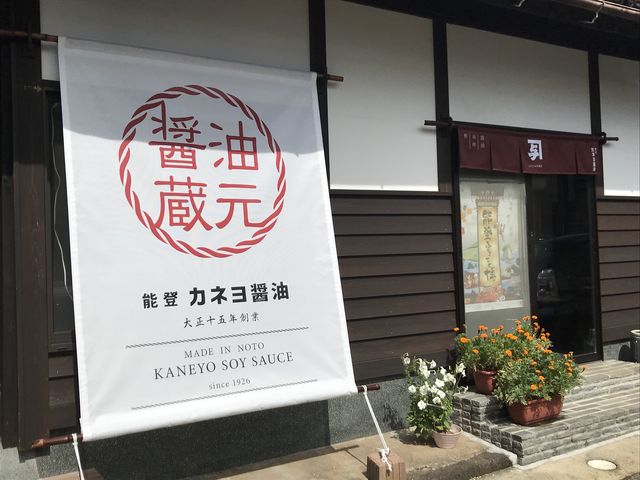 直売所外観。暖簾の前で写真を撮るお客さんも多いです。_カネヨ醤油 蔵見学