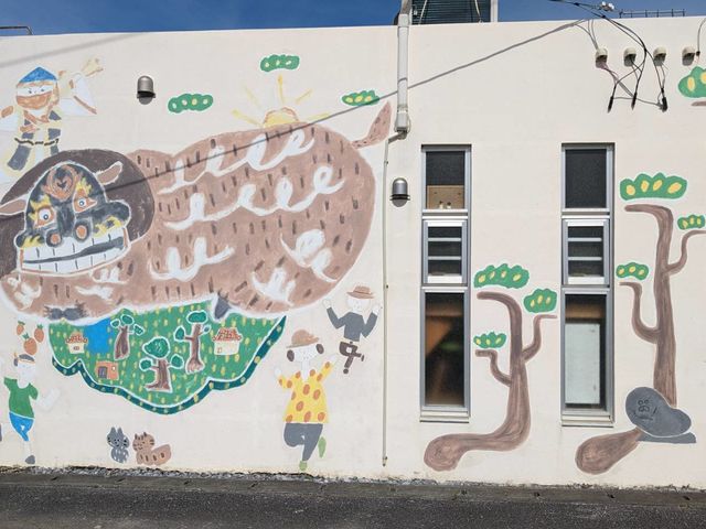 アトリエの外壁に地域の守り神「獅子ガナシー」が描かれています。よく保育園児が記念撮影をしに来る場所です。_Necocoのへや