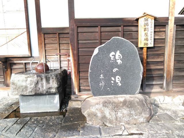 右側には説明書き、左側には風景画があります。_綿乃湯モニュメント