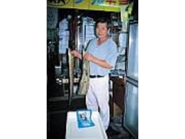 「新鮮ですよ」とウツボを手にするご主人_ぬしま鮮魚店