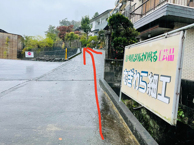 目印はこの看板車は、この坂を登りきった先に庭がありますのでそちらに駐車してください。_民藝麦わらの店 晨〜あした〜