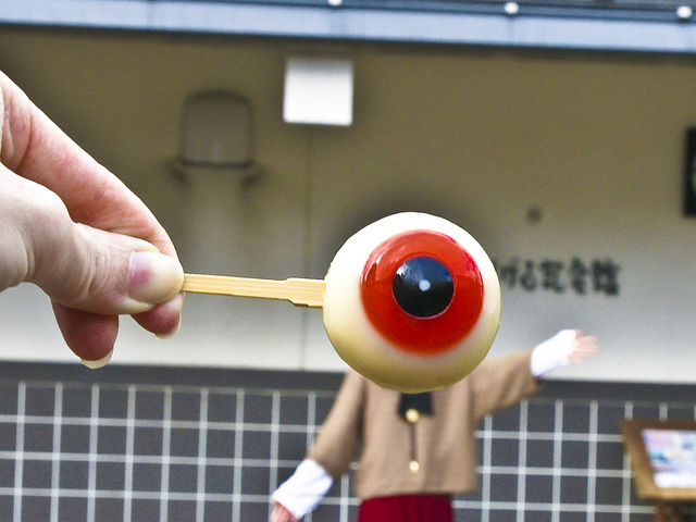 串刺しの妖菓めだまおやじを被写体の顔にもっていくと遠近法でこんな写真が!_妖怪食品研究所