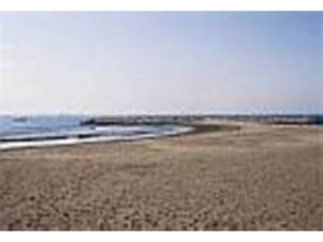 砂浜の先にT字に作られた人工の岩場がある_ヘッドランド