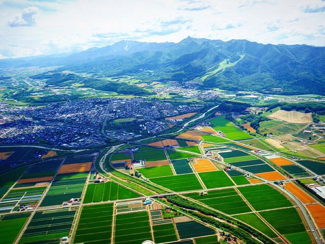 enjoy breathtaking birds-eye views of Furano town and distant active volcanoes._HOKKAIDO WINGS