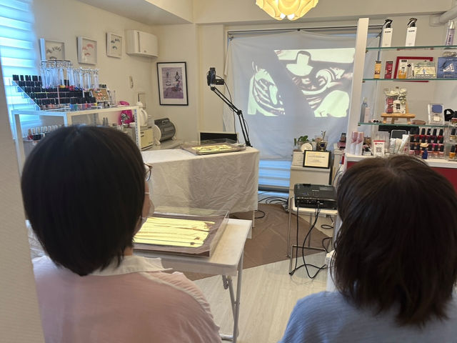 お教室の様子。スクリーンに映しながら行います。一人1テーブル。2名様の少人数レッスンです。_Caveサンドアート教室