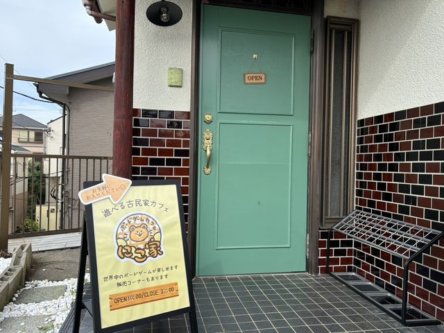 看板と緑の扉が目印です!_ボードゲームカフェにこ家
