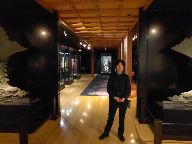 オレンジを基調にした照明の中で多数の甲冑や刀剣が展示されている_常盤木門SAMURAI館