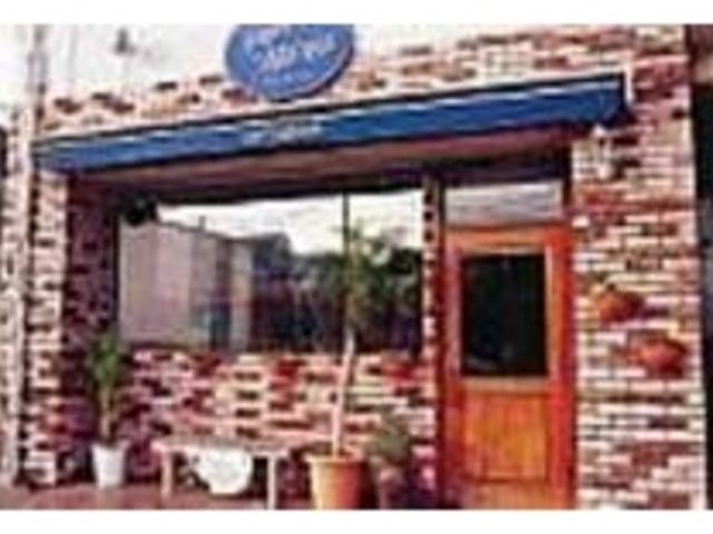 茶色の壁にブルーの看板が映える外観_ビストロ メナージュ