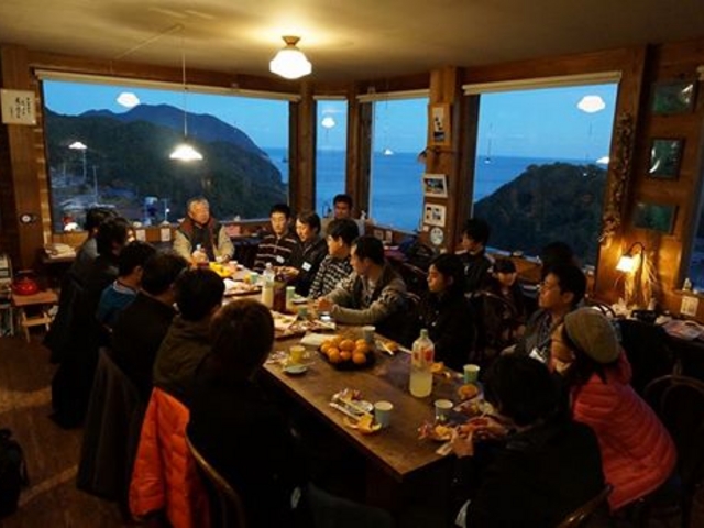 アニメ「凪のあすから」ファン交流会の写真です。海一望のカフェで皆様が交流されています。_天女座