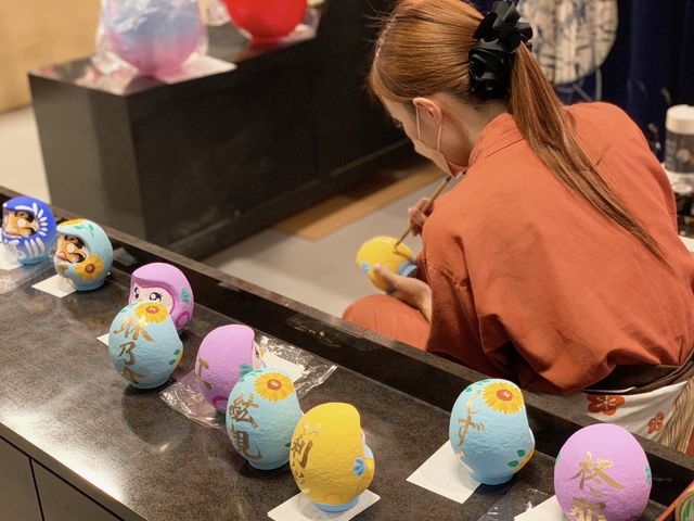 【名入れ】
絵付け体験等、ご購入いただいただるまに職人がお客様の目の前で名入れをして特別な逸品に仕上げます。(12p〜/最短5分でお渡し、即日お持ち帰り可)_だるまのふるさと大門屋