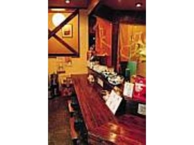 年季の入ったカウンターに座って酒を傾ける_居酒屋 お箸の国