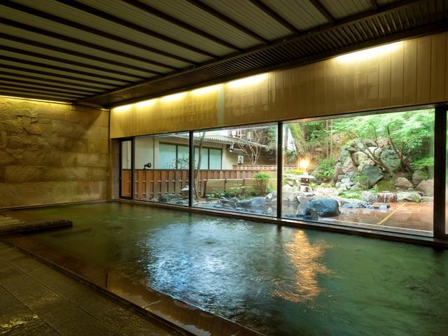 1階の大浴場。ガラスの外には庭園と池に見立てられた源泉かけ流しの露天風呂もございます。_吉田屋山王閣