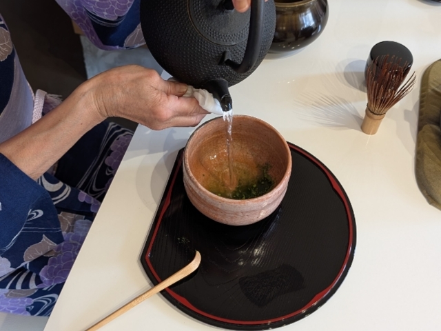 抹茶体験で抹茶にお湯を注いでいる写真_抹茶カフェ穏花