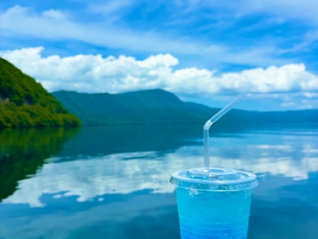 オリジナルドリンク「とわだこブルーソーダ」。湖と同じくキラキラと輝くその一杯は、旅の気分をさらに盛り上げてくれます。_Enjoy とわだこ