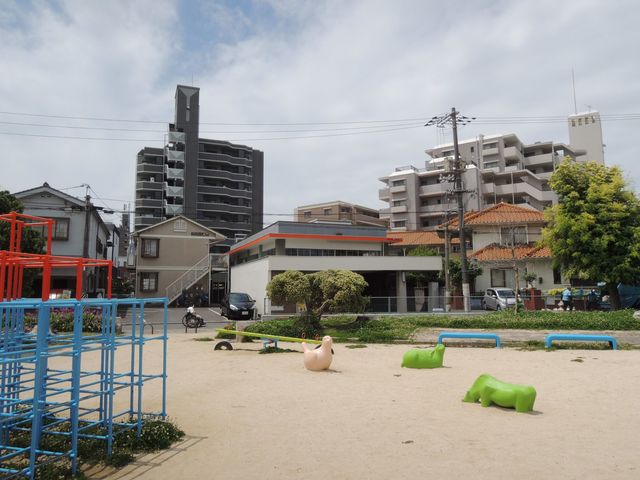 公園前の白い鉄筋コンクリートの建物です_Slow&Polite