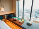 ツインルーム(2-3名定員):大きな窓越しに街の表情を眺めながら、ソファで楽しむお食事やお茶の時間も。