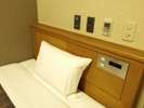 シングルルームの枕元にはコンセントも。携帯電話の充電に便利♪