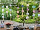 【夏の風が通る中庭のしつらえ】色とりどりの団扇が涼やかに揺れる、夏ならではの中庭装飾。