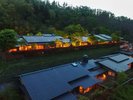 【夕暮れに灯る名月荘の外観】日が暮れはじめる頃、山あいに佇む名月荘にやわらかな灯りがともります。
