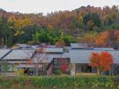【秋色に包まれる名月荘】色づく山々と客室棟が調和する、秋ならではの景色。