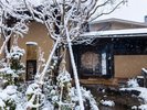 【雪に包まれる、名月荘の冬景色】外の冷たさと館内の温もりが調和する静かな情景です。