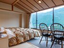 広さ55平米の新和洋室「木香り」(きこり)。ベッドの上で横になりながら下呂市街を望める