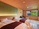 【和洋ツイン新館/一例】客室毎にカラーデザインや家具が多少異なり、窓からは庭園をご覧頂けます。