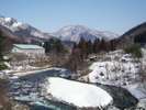 【川向うからの外観(冬)】雪が降ると一面が銀世界に。近くにはスキー場もございます。
