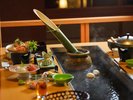 食卓の中央に温泉が湧き出る【温泉卓】(一例) ※竹酒は別注文にて承っております。