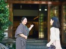 旅館の入り口で、笑顔でお出迎えいたします