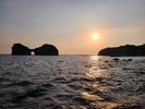 【円月島】夕日の名所として知られる。春分・秋分の時期には中心部の穴を通して夕日が見えることで有名