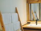 【客室】洗面台には、自社オリジナルの木製タオル掛けラックを設置しております