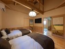 【なでしこ】モダンなツイン寝室。ふすま絵が印象的で、奥の和室へと繋がる落ち着いた空間です。