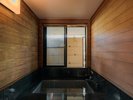 【桜|石造風呂】石の重厚感と木の温もりが調和する源泉かけ流し風呂。